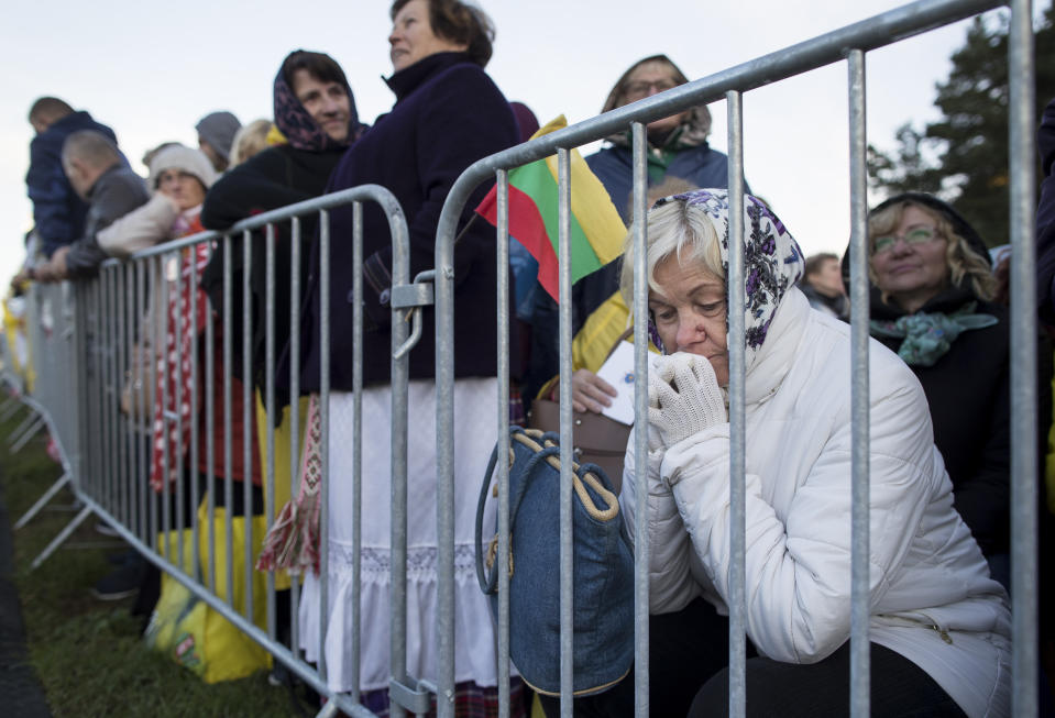 A woman prays as they wait for Pope Francis to arrive to celebrate a Mass in Confluence Park in Kaunas, Lithuania, Sunday, Sept. 23, 2018. Pope Francis is on the second of his two-day visit to Lithuania. (AP Photo/Mindaugas Kulbis)