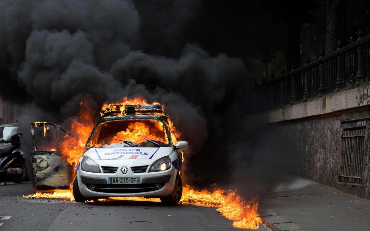 Nine people are on trial for attacking and incinerating a police car during an unauthorized counter-demonstration against police violence - AFP