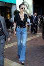 <p>In a deep V t-shirt, belted Rag & Bone flare jeans, black pumps and rounded sunglasses while out in Cannes. </p>