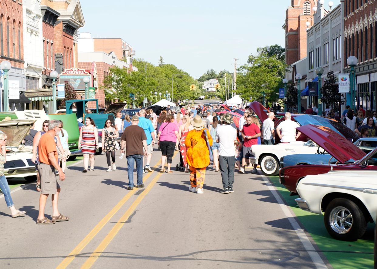 People stroll down East Maumee Street among the classic cars in downtown Adrian June 4, 2021, during First Fridays. The Cruise-in Car Show returns for the 2022 summer season today with no-charge registration beginning at 4 p.m.