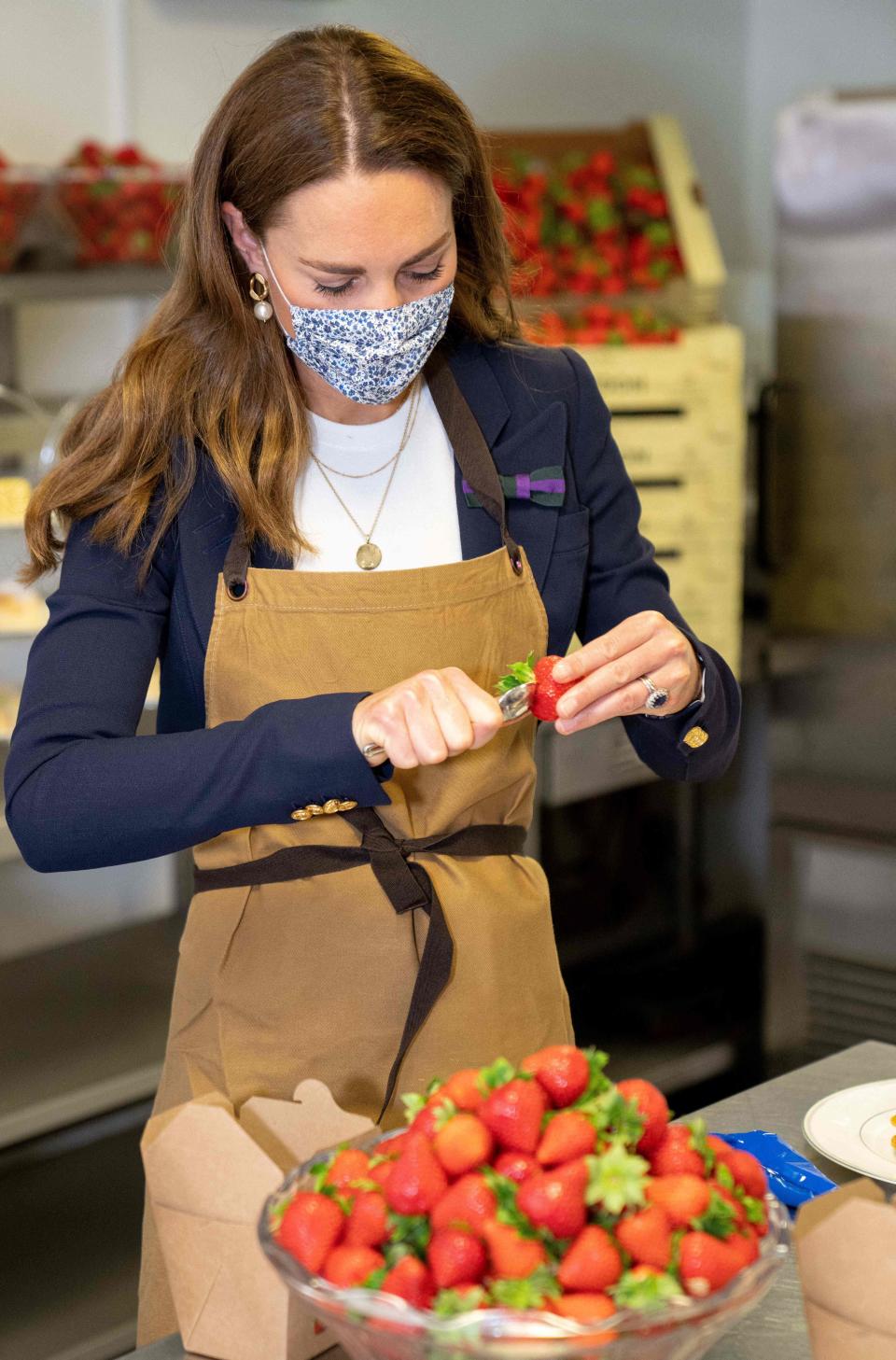 Britain's Catherine, Duchess of Cambridge, Patron of the All England Lawn Tennis Club, preparies strawberries in the Wingfield kitchen during her visit on the fifth day of the 2021 Wimbledon Championships at The All England Tennis Club in Wimbledon, southwest London, on July 2, 2021. - RESTRICTED TO EDITORIAL USE (Photo by AELTC/Thomas Lovelock / POOL / AFP) / RESTRICTED TO EDITORIAL USE (Photo by AELTC/THOMAS LOVELOCK/POOL/AFP via Getty Images)