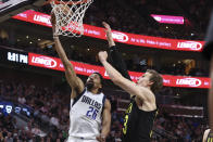 Dallas Mavericks guard Spencer Dinwiddie (26) lays up the ball against Utah Jazz forward Lauri Markkanen, right, in the first half of an NBA basketball game Saturday, Jan. 28, 2023, in Salt Lake City. (AP Photo/Rob Gray)