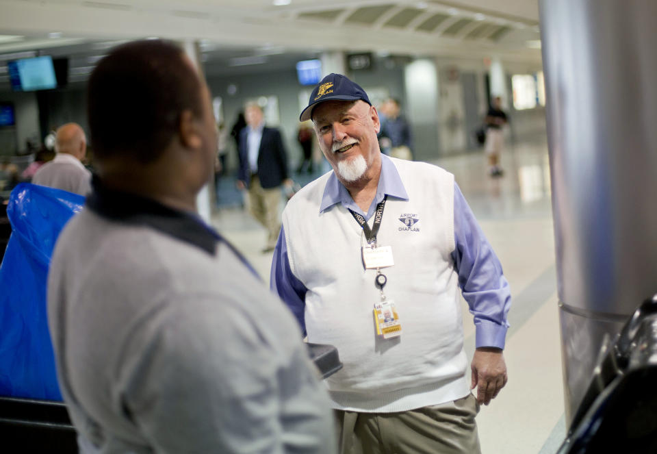 In this Tuesday, Oct. 15, 2013 photo, airport chaplain Rev. Frank Colladay Jr., right, talks with airport worker Lance Norris as he makes his rounds through a concourse at Hartsfield-Jackson International Airport, in Atlanta. Airports are mini-cities with their own movie theaters, fire departments and shopping malls. Many also have chapels, which are staffed by a mix of 350 part- and full-time chaplains worldwide who are Catholic, Protestant and, to a lesser extent, Jewish, Muslim or Sikh. (AP Photo/David Goldman)
