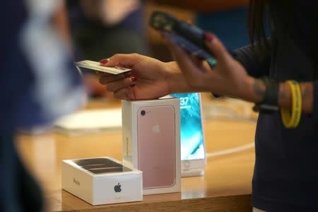 A customer buys the new iPhone 7 smartphone inside an Apple Inc. store in Los Angeles, California, U.S., September 16, 2016. REUTERS/Lucy Nicholson - RTSO2V4