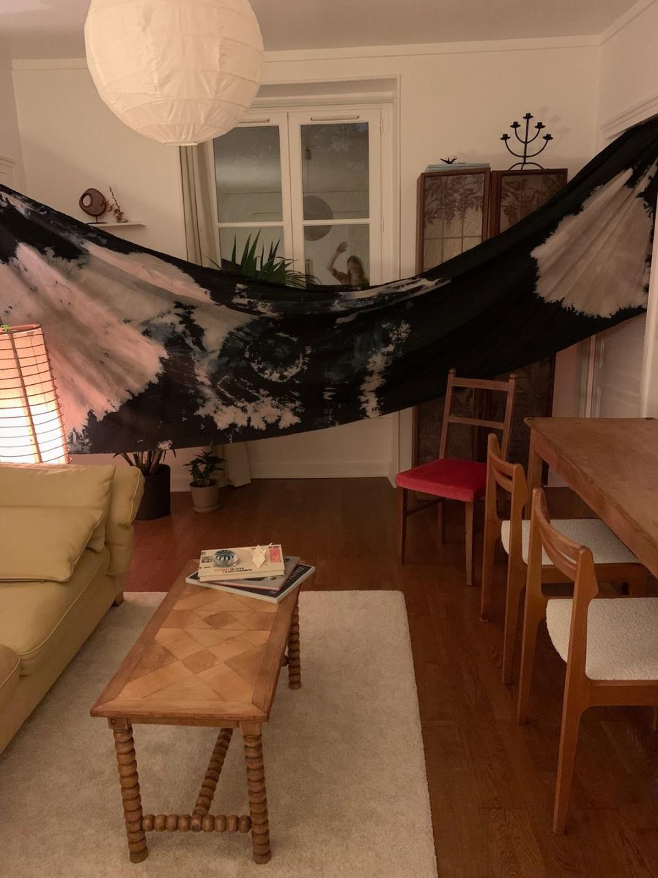 a living room with tie dye fabric drying