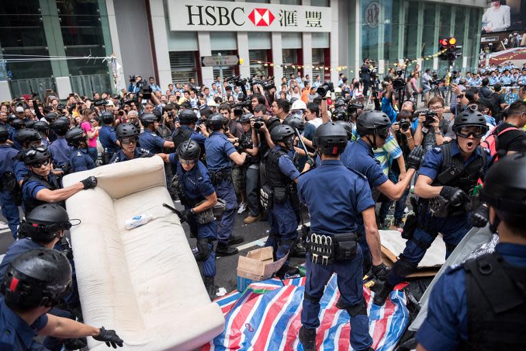 Police move a couch as they clear away a pro-democracy protest camp in the Mongkok district of Hong Kong on November 26, 2014