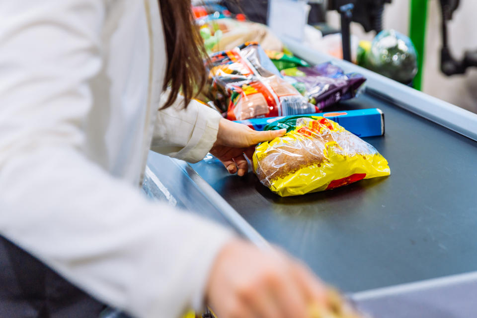 woman put products on the line near cashbox. grocery shopping concept