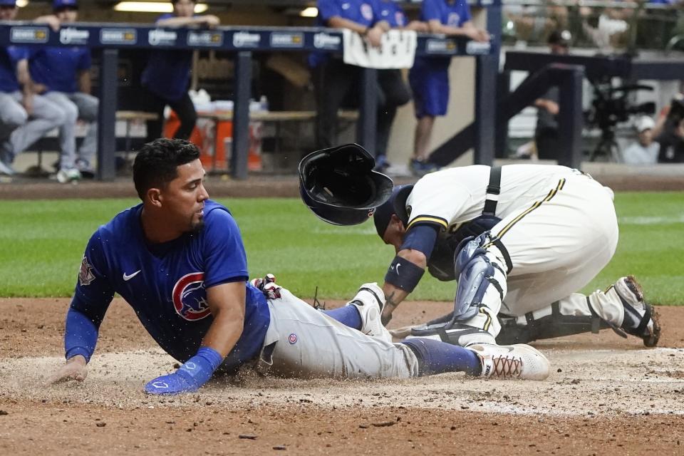 Chicago Cubs' Rafael Ortega slides safely past Milwaukee Brewers catcher Victor Caratini as he steals home during the sixth inning of a baseball game Tuesday, July 5, 2022, in Milwaukee. (AP Photo/Morry Gash)