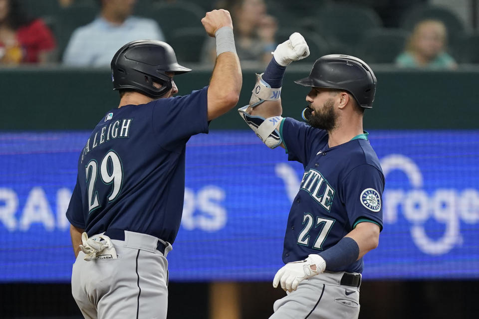 Seattle Mariners' Kesse Winker (27) celebrates his two-run home run at home plate with teammate Cal Raleigh (29) during the fifth inning of a baseball game against the Texas Rangers in Arlington, Texas, Saturday, June 4, 2022. (AP Photo/LM Otero)