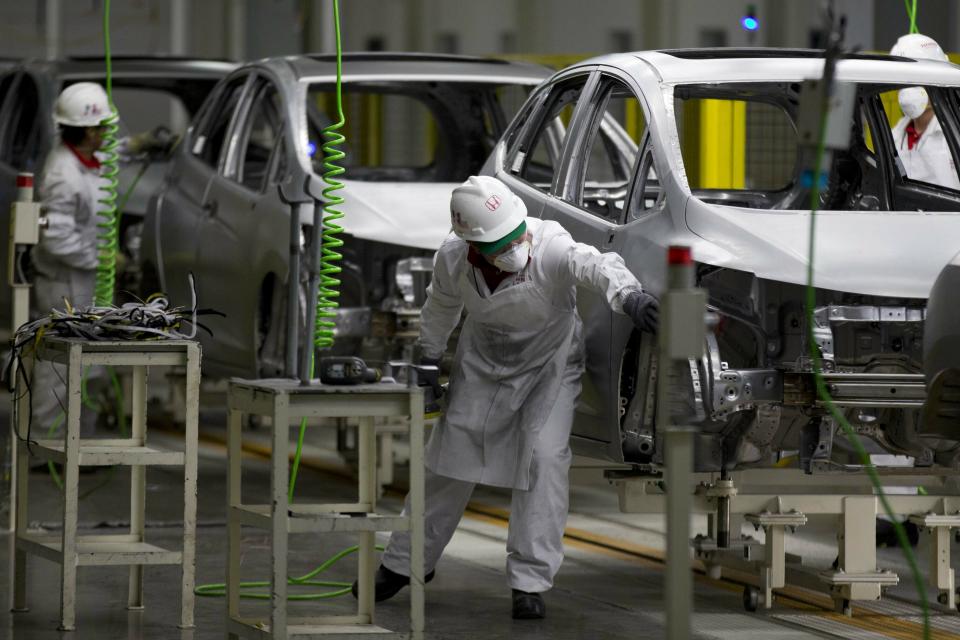 FILE- In this Feb. 21, 2014, file photo employees work in a Honda car plant in Celaya, in the central Mexican state of Guanajuato. Backing away from his vow to close America’s southern border, President Donald Trump on Thursday, April 4, 2019, and Friday promised instead that he’d slap tariffs on cars imported from Mexico if the illegal flow of people and narcotics doesn’t stop. (AP Photo/Eduardo Verdugo, File)