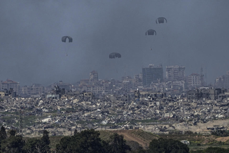 Parachutes drop supplies into the northern Gaza Strip, as seen from southern Israel, Wednesday, March 13, 2024. (AP Photo/Tsafrir Abayov)