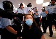 A protester is detained by the police officers at Amoy Plaza shopping mall in Kowloon Bay, Hong Kong