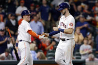 Houston Astros' fielder Myles Straw, left, and Kyle Tucker, right, celebrate Tucker's home run during the fifth inning of a baseball game against the Los Angeles Angels Tuesday, May 11, 2021, in Houston. (AP Photo/Michael Wyke)