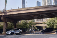 A police officer sits at his car as he guards outside One Police Plaza NYPD Headquarters on Friday, Sept. 13, 2024, in New York. (AP Photo/Andres Kudacki)