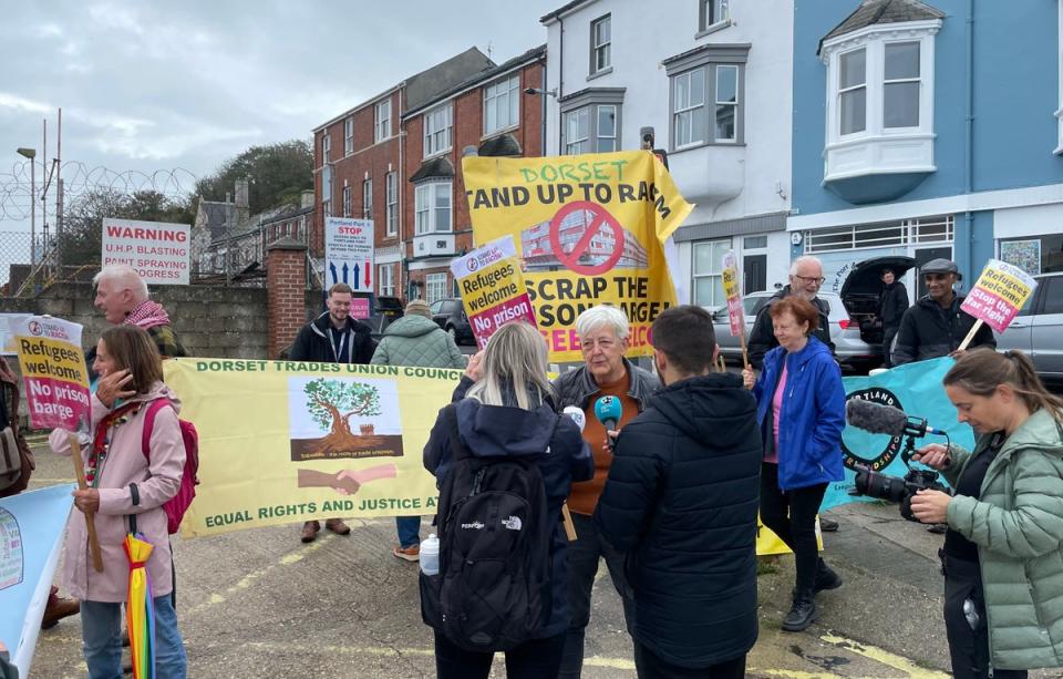 Candy Udwin, of Stand Up Against Racism Dorset, speaks to the media during a protest near the Bibby Stockholm accommodation barge at Portland Port in Dorset. (PA)