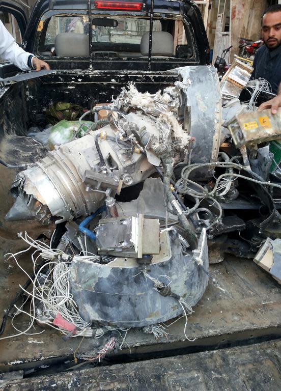 Fighters from the Islamic State (IS) group load a van with wreckage they said was a US drone that crashed into a communications tower in the Syrian city of Raqa, on September 23, 2014