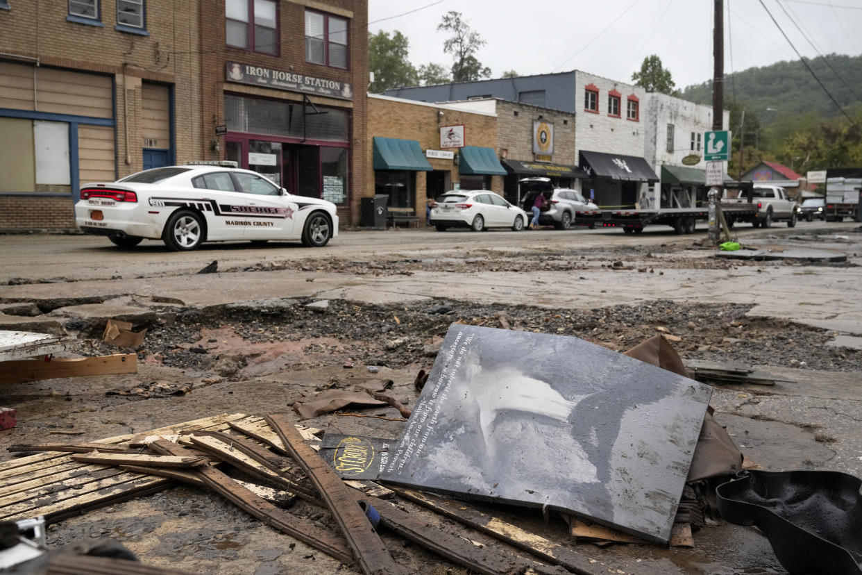 A Madison County sheriff's vehicle passes damaged buildings along Bridge Street in the aftermath of Hurricane Helene Tuesday, Oct. 1, 2024, in Hot Springs, N.C. (AP Photo/Jeff Roberson)