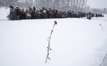 People walk in snowfall to place flowers to the Motherland monument at the Piskaryovskoye Cemetery where most of the Leningrad Siege victims were buried during World War II, in St. Petersburg, Russia, Saturday, Jan. 26, 2019. People gathered to mark the 75th anniversary of the battle that lifted the Siege of Leningrad. The Nazi German and Finnish siege and blockade of Leningrad, now known as St. Petersburg, was broken on Jan. 18, 1943 but finally lifted Jan. 27, 1944. More than 1 million people died mainly from starvation during the 900-day siege. (AP Photo/Dmitri Lovetsky)