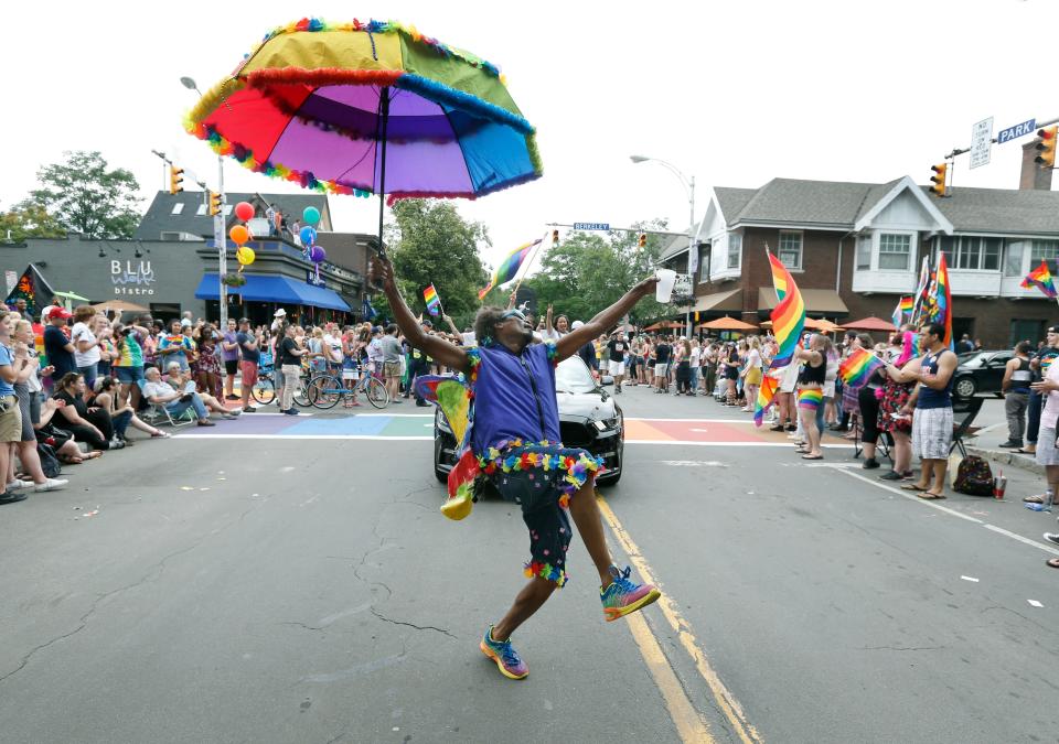 Carlos Merriweather who labels himself "Rochester's Social Butterfly", gets the crowd's attention at the intersection of Park Avenue and Berkeley Street during the ROC Pride parade.