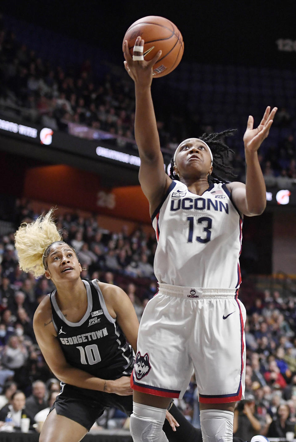 Connecticut's Christyn Williams shoots ahead of Georgetown's Kaylin West (10) during the first half of an NCAA college basketball game in the quarterfinals of the Big East Conference tournament at Mohegan Sun Arena, Saturday, March 5, 2022, in Uncasville, Conn. (AP Photo/Jessica Hill)