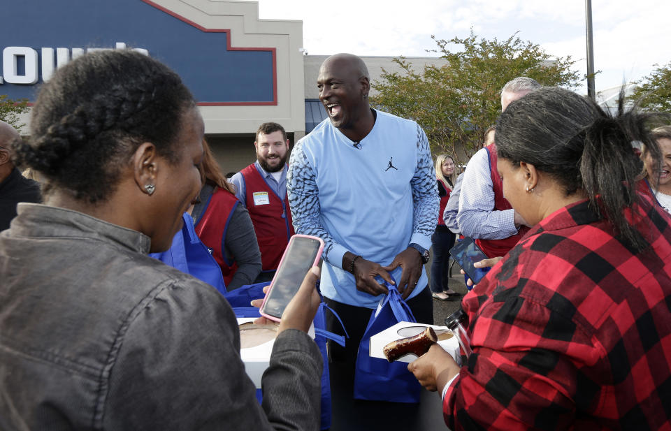 Charlotte Hornets owner Michael Jordan greets people and hands out food for Thanksgiving to members of the community in Wilmington, N.C., Tuesday, Nov. 20, 2018. (AP Photo/Gerry Broome)