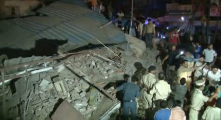 Policemen and locals gather at the site after a four-story hotel collapsed in a crowded part of the central Indian city of Indore late on Saturday, in this still image taken from video released on April 1, 2018. ANI/via REUTERS TV
