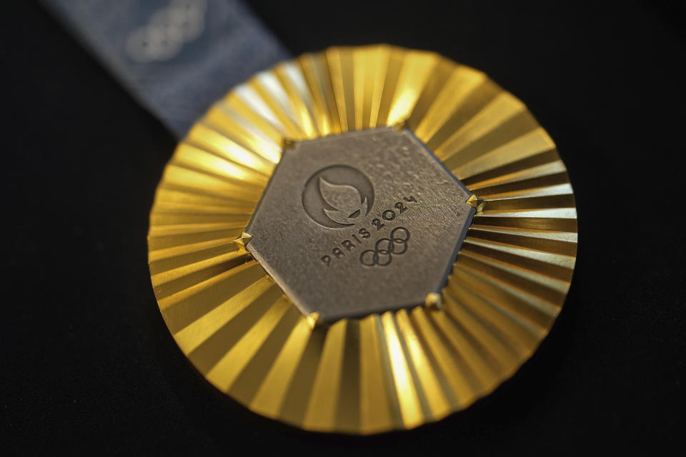 The Paris 2024 Olympic gold medal is presented to the press, in Paris, Thursday, Feb. 1, 2024. A hexagonal, polished piece of iron taken from the Eiffel Tower is being embedded in each gold, silver and bronze medal that will be hung around athletes' necks at the July 26-Aug. 11 Paris Games and Paralympics that follow. (AP Photo/Thibault Camus)