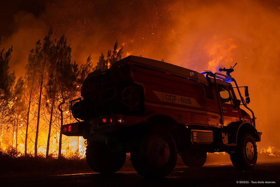 This photo provided by the fire brigade of the Gironde region SDIS 33, (Departmental fire and rescue service 33) shows firefighters tackling a blaze near Saint-Magne, south of Bordeaux, southwestern France, Wednesday, Aug. 10, 2022. (SDIS 33 via AP)