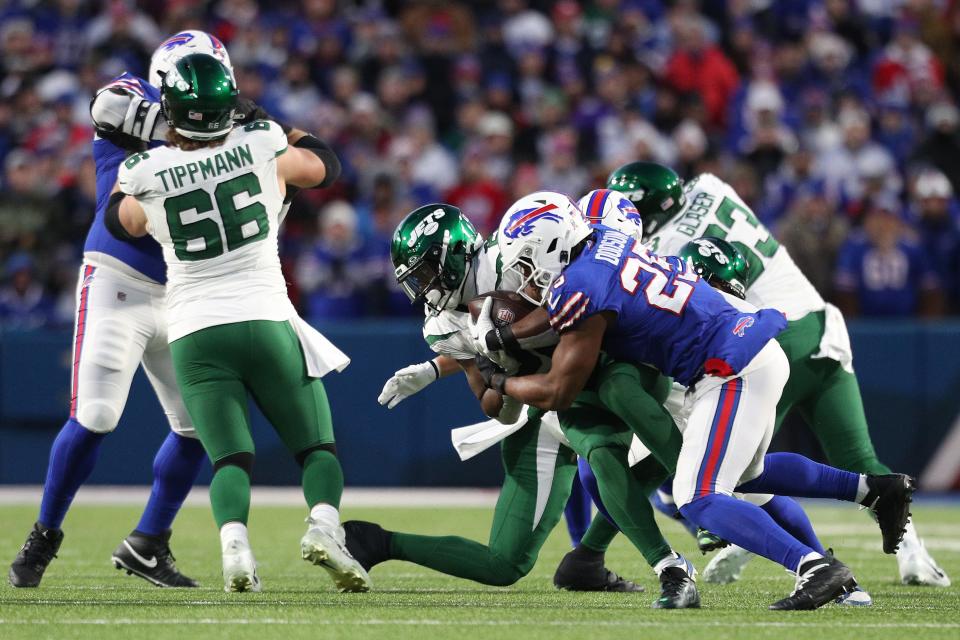 ORCHARD PARK, NEW YORK - NOVEMBER 19: Breece Hall #20 of the New York Jets runs with the ball while being tackled by Tyrel Dodson #25 of the Buffalo Bills in the first quarter at Highmark Stadium on November 19, 2023 in Orchard Park, New York. (Photo by Bryan M. Bennett/Getty Images)