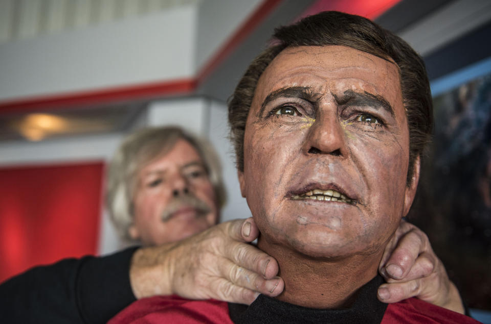 In this Saturday, March 25, 2017 photo, Steve Greenthal adjusts the wax head of Star Trek character Scotty at the Fullerton Airport in Fullerton, Calif. The Orange County Register says the figures were crafted for the Movieland Wax Museum in Buena Park, which auctioned everything off when it closed about a decade ago. (Nick Agro/The Orange County Register via AP)