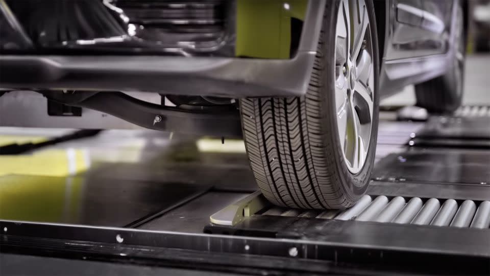 The tire of an electric vehicle in position for battery swapping inside the Ample machine. - Courtesy Ample