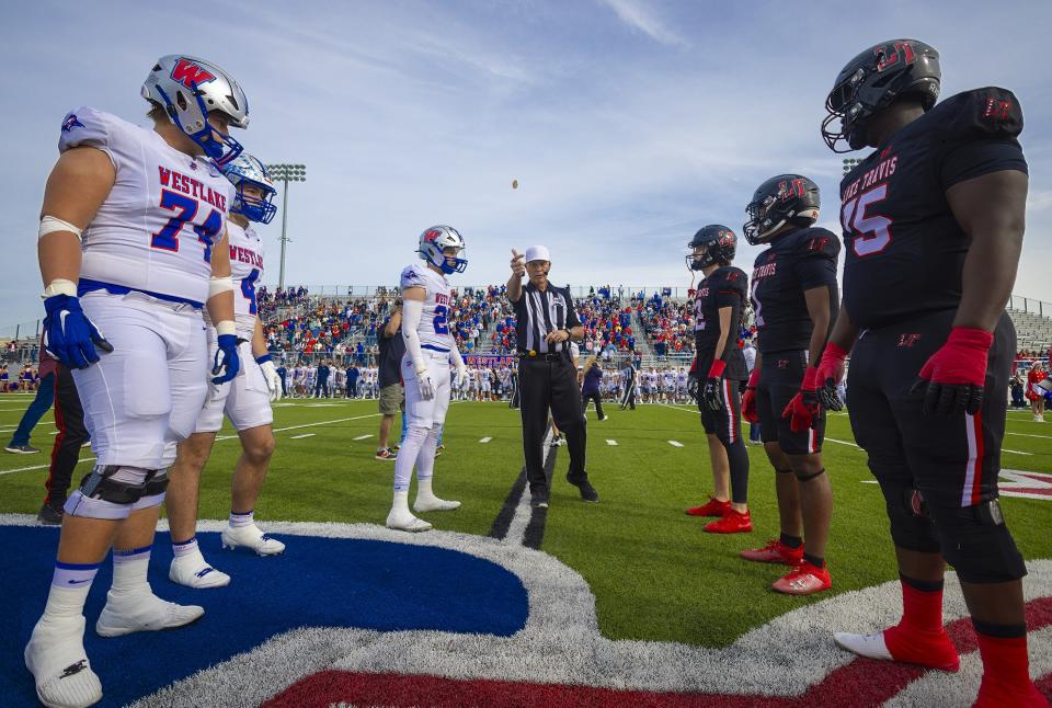 Referee Wayne Elliott tosses the coin between the Lake Travis Cavaliers and the Westlake Chaparrals captains before the kickoff at the Class 6A D1 quarterfinal football game on Saturday, Dec 2, 2023, at the Pfield Stadium - Pflugerville, TX.