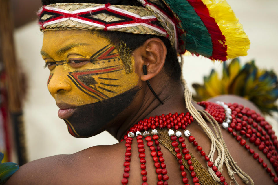 A Pataxo Indian waits to participate in the building of a human banner on Flamengo beach, organized by Amazon Watch, on the sidelines of the Rio+20, or UN Conference on Sustainable Development in Rio de Janeiro, Brazil, Tuesday, June 19, 2012. The activists are calling attention to threats posed to rivers, forests and livelihoods by large hydroelectric dams, like the Belo Monte hydroelectric plant being constructed in Brazil's Amazon. (AP Photo/Victor R. Caivano)