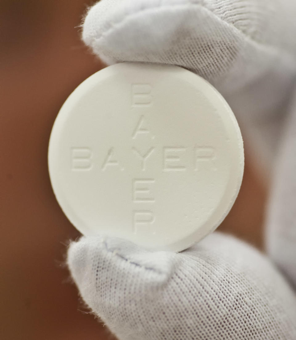 In this photo taken July 6, 2009 worker Roland Ulbrich presents an Aspirin pill made for Italy at the pharmaceutical plant of the Bayer Bitterfeld company in Bitterfeld-Wolfen, eastern Germany. Germany's Bayer AG says it plans to buy U.S. pharmaceutical company Merck & Co. Inc.'s consumer care business, whose products include the Coppertone suncare range, Claritin allergy medicine and the Dr. Scholl's footcare products, for US$ 14.2 billion. (AP Photo/Eckehard Schulz)