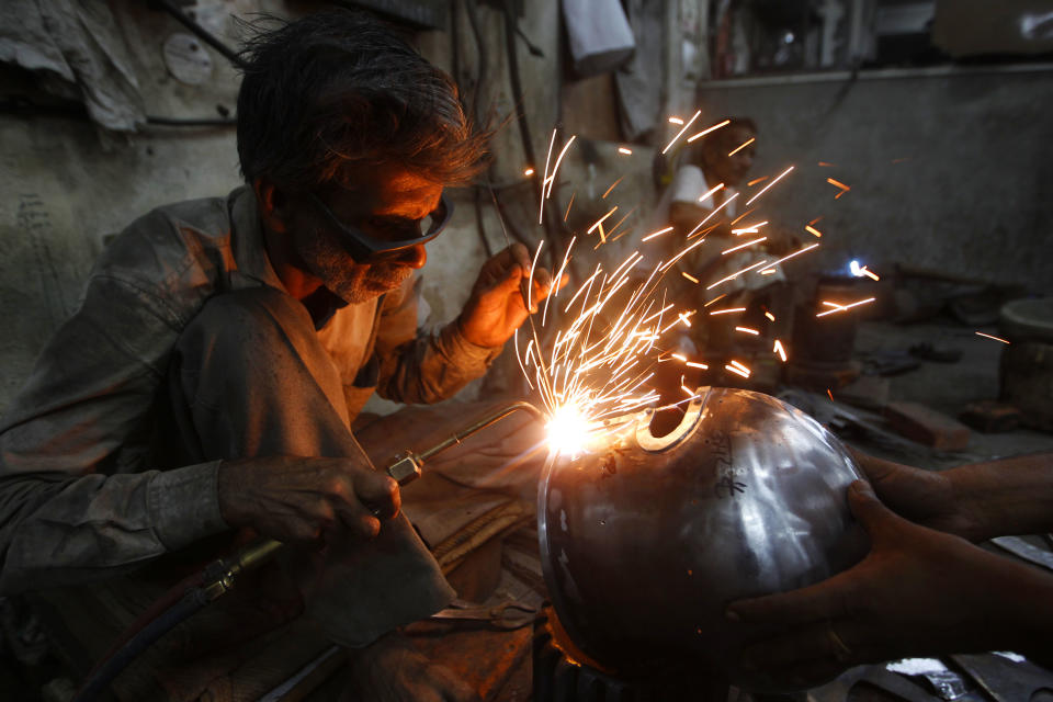 In this, June 2, 2012 photograph, a worker welds a part of a helmet being prepared for a Hollywood period movie at a workshop owned by Indian businessman Ashok Rai, unseen, in Sahibabad, India. From Hollywood war movies to Japanese Samurai films to battle re-enactments across Europe, Rai is one of the world's go-to men for historic weapons and battle attire.(AP Photo/Saurabh Das)