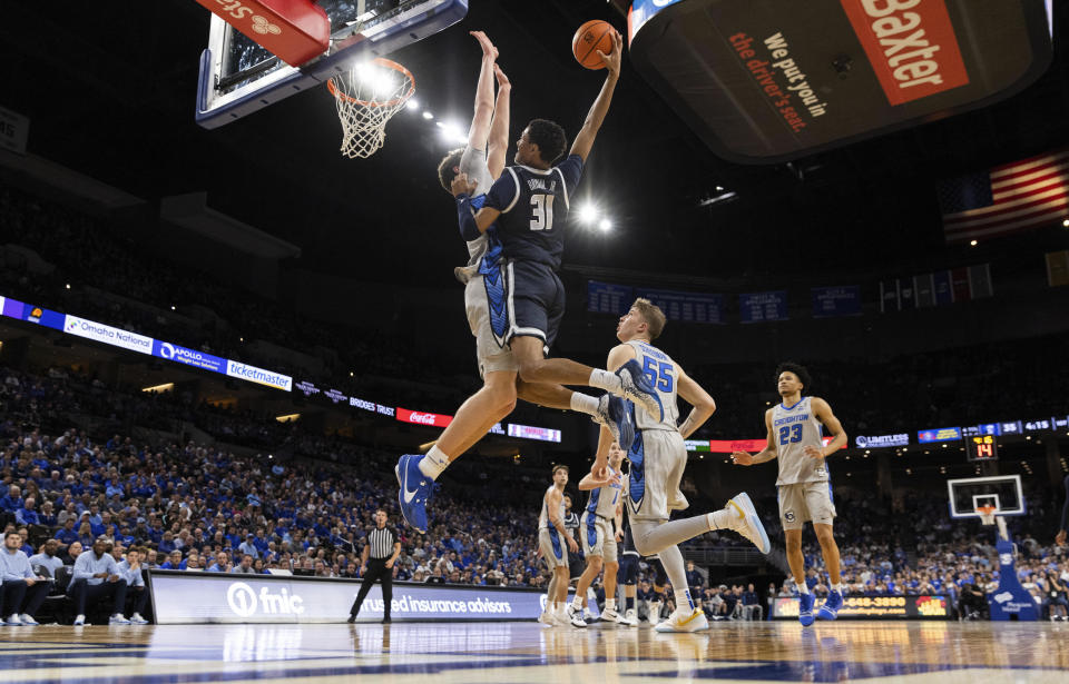 Georgetown's Wayne Bristol Jr., second left, shoots against Creighton's Ryan Kalkbrenner, left, during the first half of an NCAA college basketball game, Tuesday, Feb. 13, 2024, in Omaha, Neb. (AP Photo/Rebecca S. Gratz)