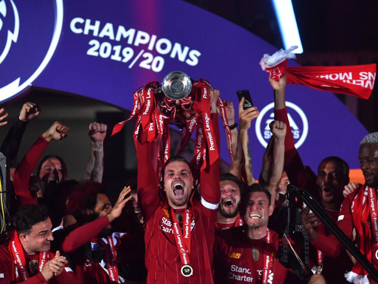 Jordan Henderson lifts the trophy: Getty