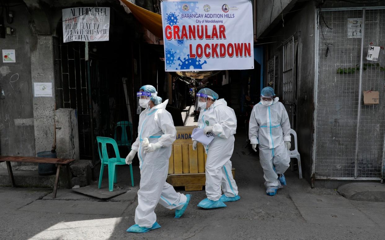 Filipino health workers In PPE perform swab tests on a village in Manila - Aaron Favila/AP