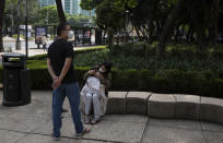 A woman comforts her son after being evacuated from a building during a 7.5 earthquake, in Mexico City, Tuesday, June 23, 2020. The earthquake centered near the resort of Huatulco in southern Mexico swayed buildings Tuesday in Mexico City and sent thousands into the streets.(AP Photo/Fernando Llano)