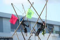 Two protesters use bamboo lock-ons to block the road outside the Newsprinters printing works at Broxbourne, Hertfordshire. (Photo by Yui Mok/PA Images via Getty Images)