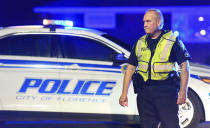 A police officer directs traffic on Hoffmeyer Road near the Vintage Place neighborhood where three deputies and two city officers were shot Wednesday, Oct. 3, 2018, in Florence, S.C. (AP Photo/Sean Rayford)