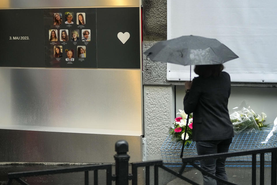 A woman stands in front of the Vladislav Ribnikar school prior to a ceremony to mark the first anniversary of a shooting that killed 10 people in Belgrade, Serbia, Friday, May 3, 2024. (AP Photo/Darko Vojinovic)