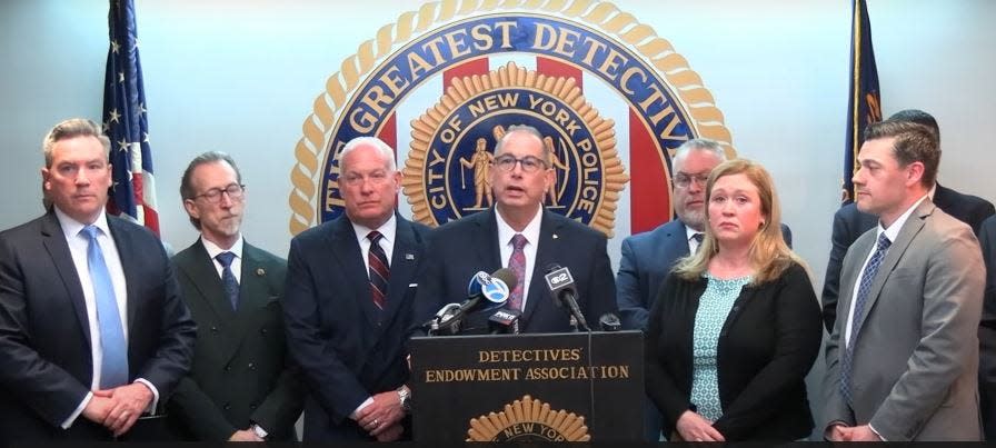 Paul DiGiacomo, president of the NYPD's Detectives' Endowment Association, flanked by members of his group and Karen and James Whalen, the sister and brother-in-law of Megan McDonald, calls for the FBI and or Attorney General to investigate the actions of Orange County District Attorney David M. Hoovler. The DA, when he was in private practice, represented Andre Thurston, a man who was seeking a plea deal in the McDonald murder. Hoovler, after taking office in January 2014, failed to recuse himself from overseeing the investigation.
