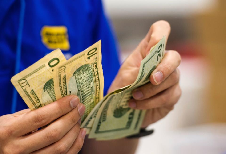 A Best Buy Co. employee counts U.S. twenty and ten dollar banknotes at a Best Buy Co. store ahead of Black Friday in San Francisco, California, U.S. (Photo: David Paul Morris/Bloomberg via Getty Images)