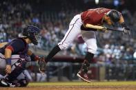 Arizona Diamondbacks' Nick Ahmed, right, jumps out of the way of an inside pitch as Washington Nationals catcher Alex Avila, left, makes the catch during the seventh inning of a baseball game Sunday, May 16, 2021, in Phoenix. (AP Photo/Ross D. Franklin)