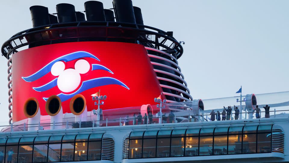 Passengers stand on the deck of Disney Dream, a Disney Cruise Lines' ship, as it sails to the Bahamas on August 9, 2021. - Joe Skipper/Reuters