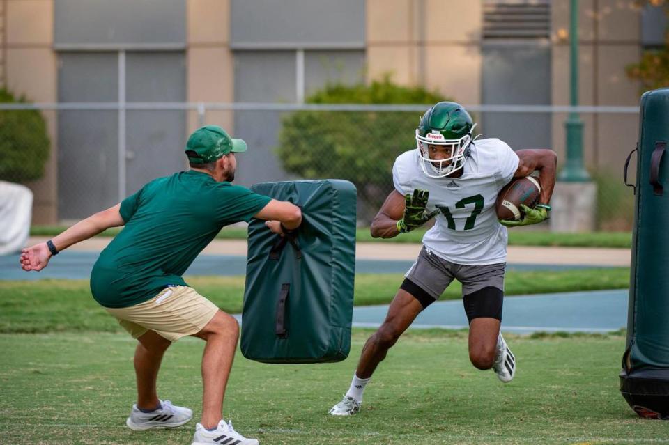 Sacramento State Hornet wide receiver Kyran Griffin-Isom runs through wide receivers coach Tyler Osborne in a drill during practice July 31.