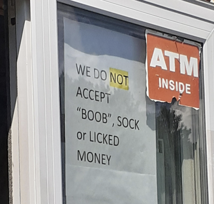 Sign on a window reads "WE DO NOT ACCEPT 'BOOB', SOCK OR LICKED MONEY" next to an "ATM inside" sign