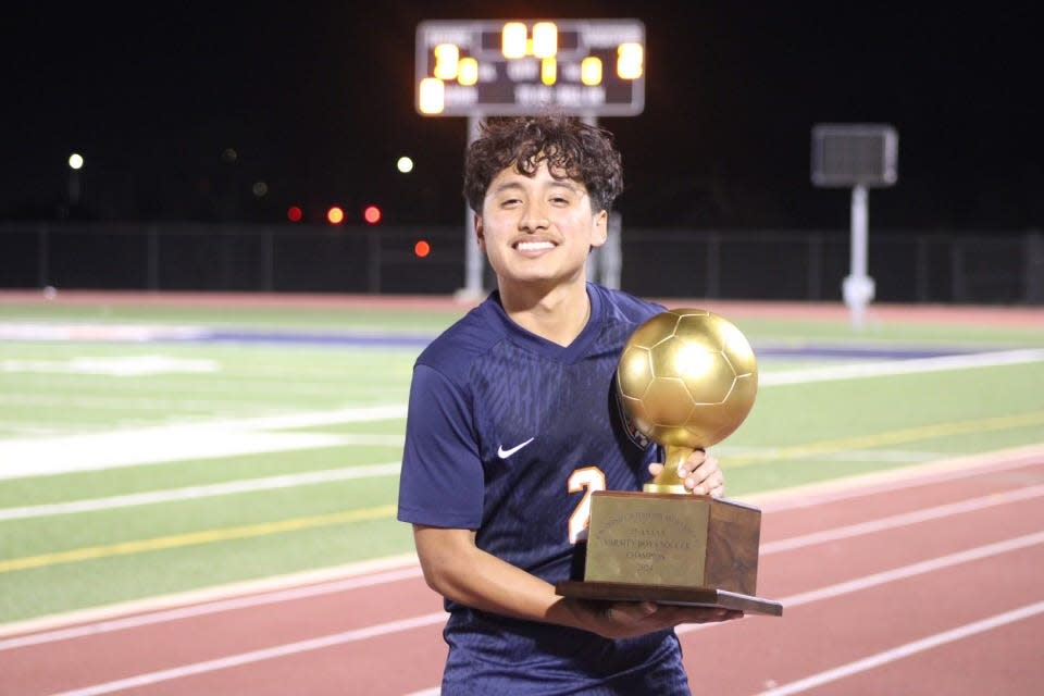 Glenn junior Tito Don Juan, holding the District 25-5A championship trophy, had 25 goals and 23 assists to help the Grizzlies to the Class 5A state tournament.