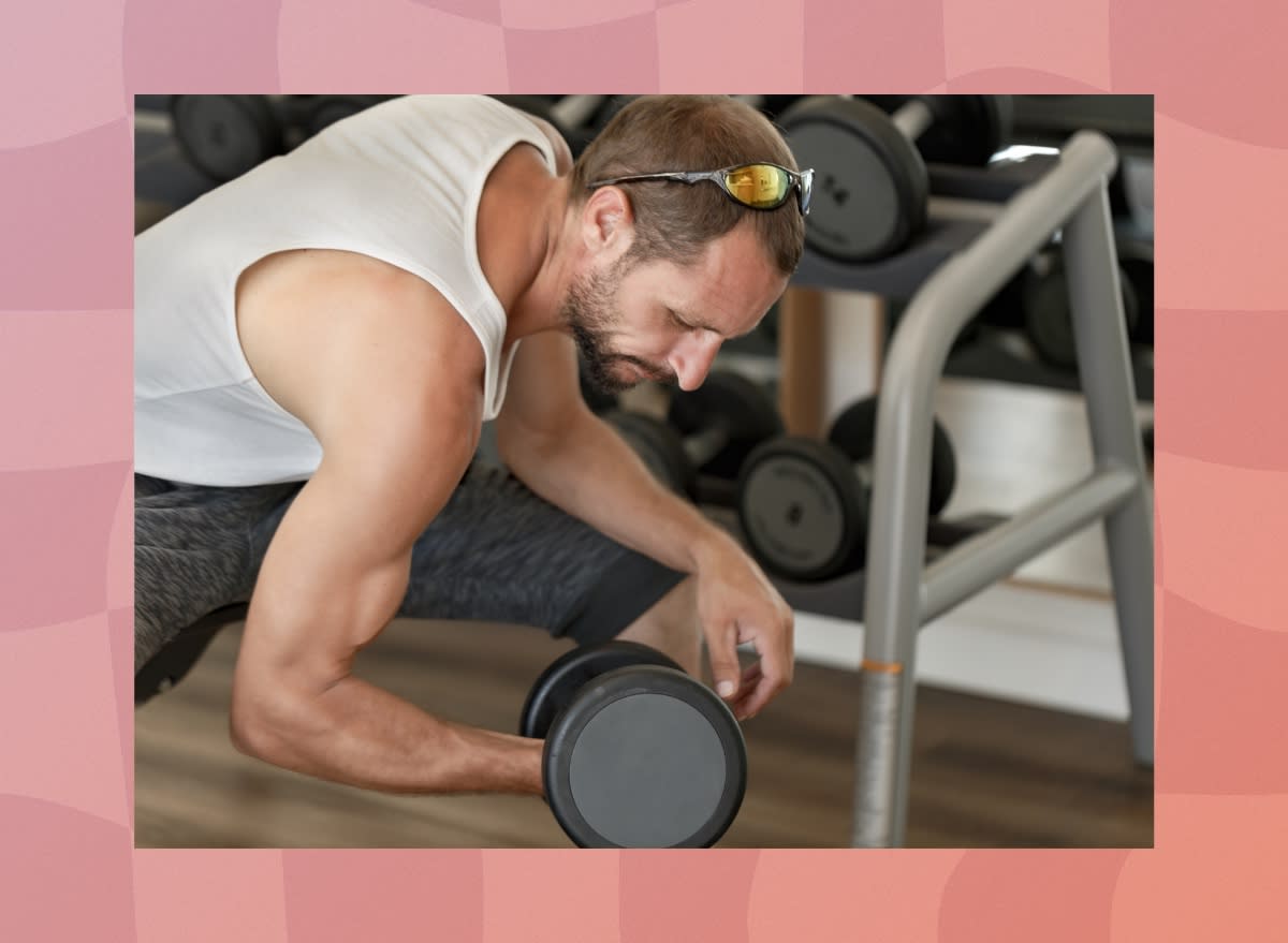 focused, fit middle-aged man doing dumbbell wrist curl to work on grip strength at the gym